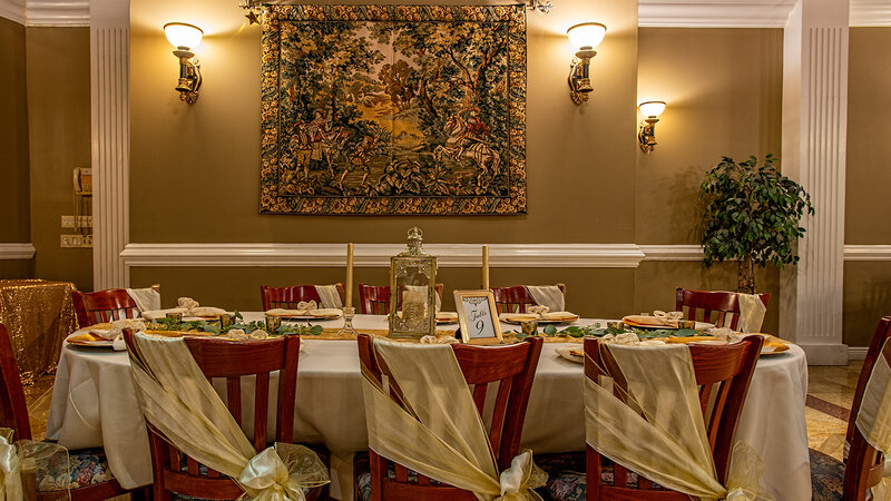 Long table set for 8 eights with tapestry hung from wall